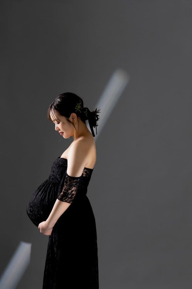 黒いドレス、お腹に手を添えた横顔