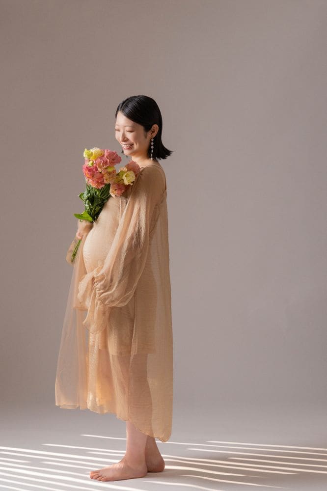 花を手にした、素足のシフォンドレス