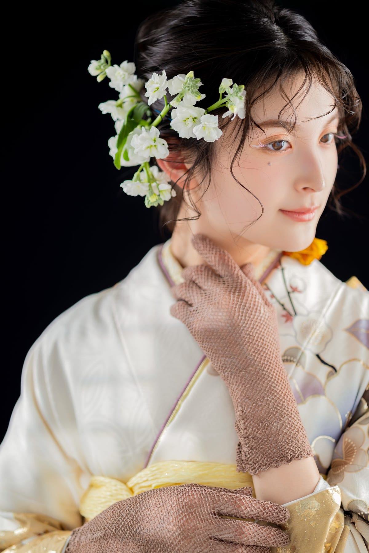 黒背景に白い振袖と白い花の髪飾りを合わせて撮影した成人式の前撮り写真