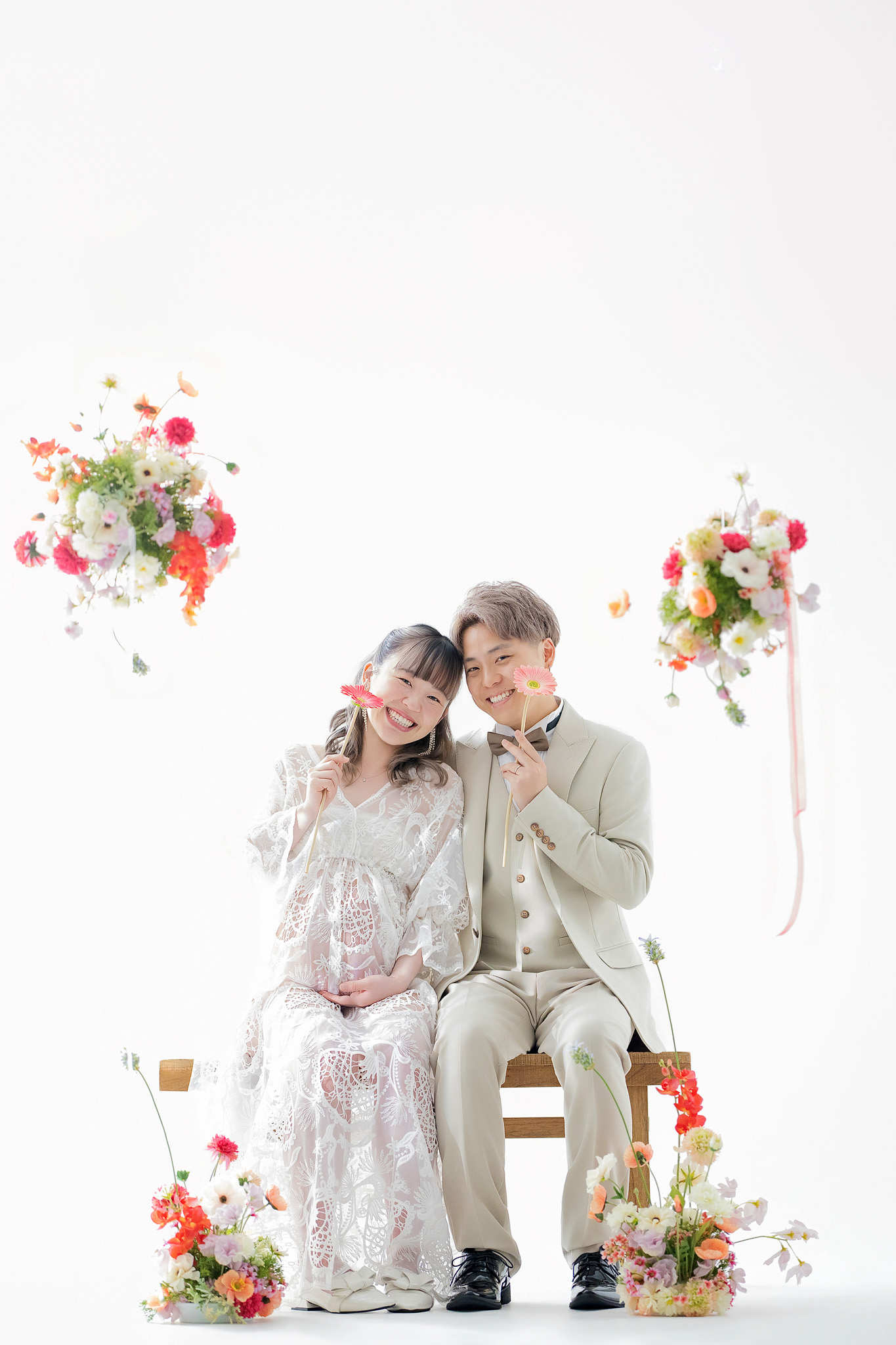 装花を配したセットの中で、椅子に並んで座るご夫婦