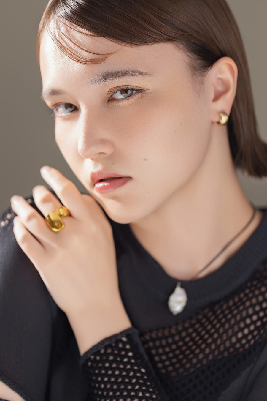 黒のメッシュトップスに指輪を重ね、正面を向いたプロフィール写真