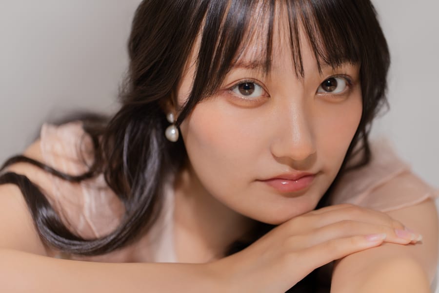 腕に頭をあずけて正面を見る、横長の構図のプロフィール写真